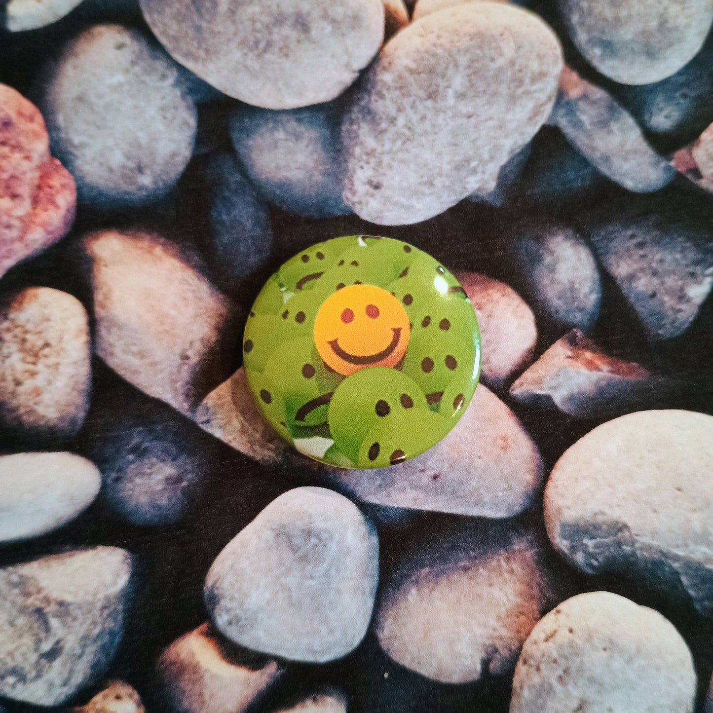 Yellow Smiley in a crowd of Greens pin badge